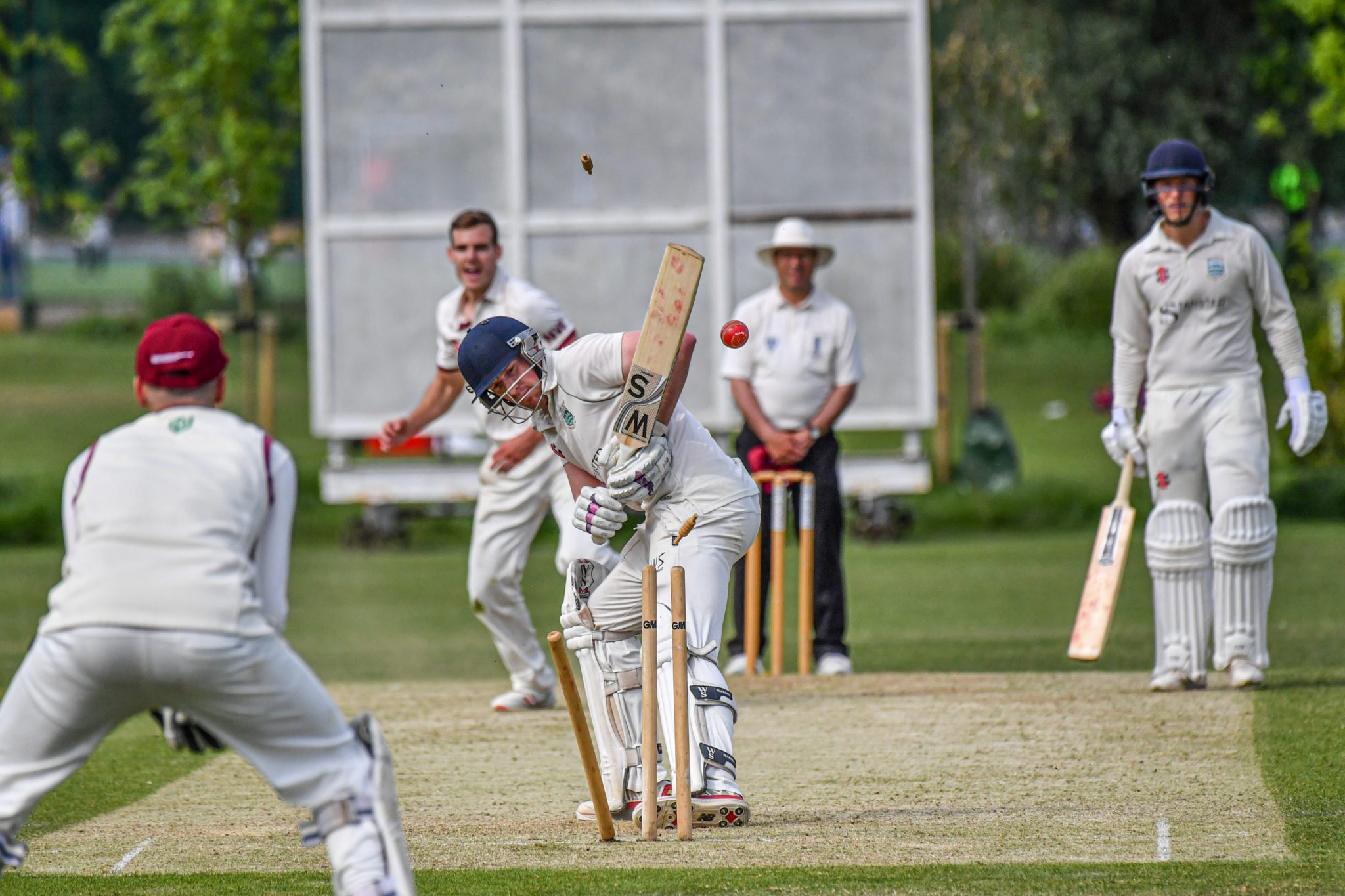 Cricket batsman mid-shot during an Essex League match