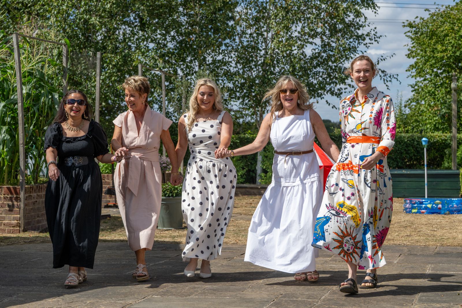 Guests laughing together at a summer garden party in Essex, photographed by Jon Wagstaff