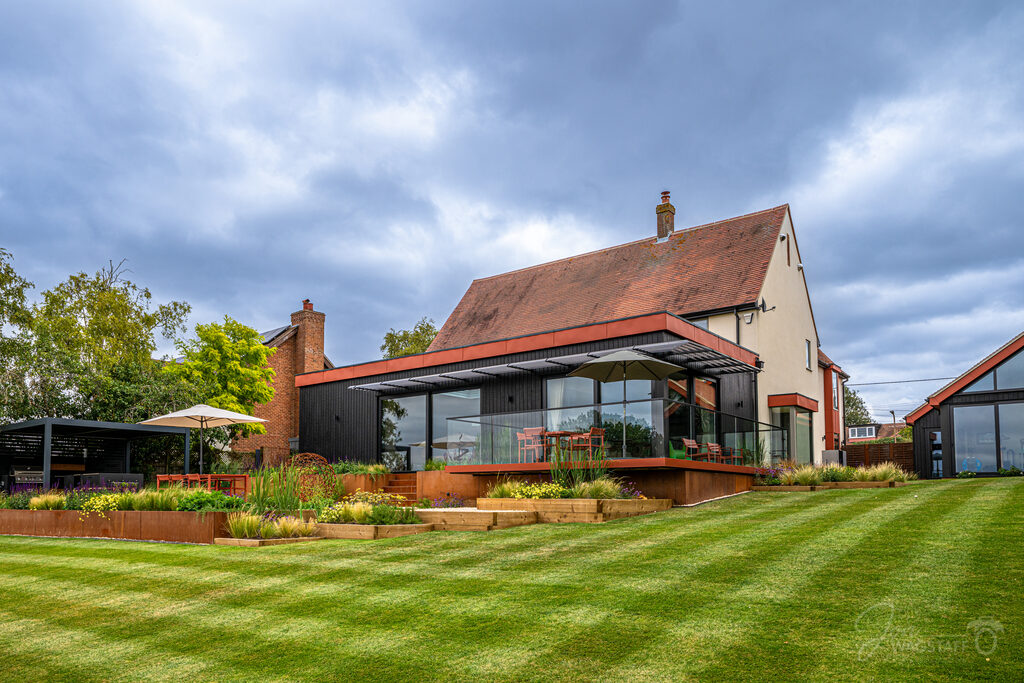 Warwick House rear extension under a dramatic Essex sky, photographed by Jon Wagstaff