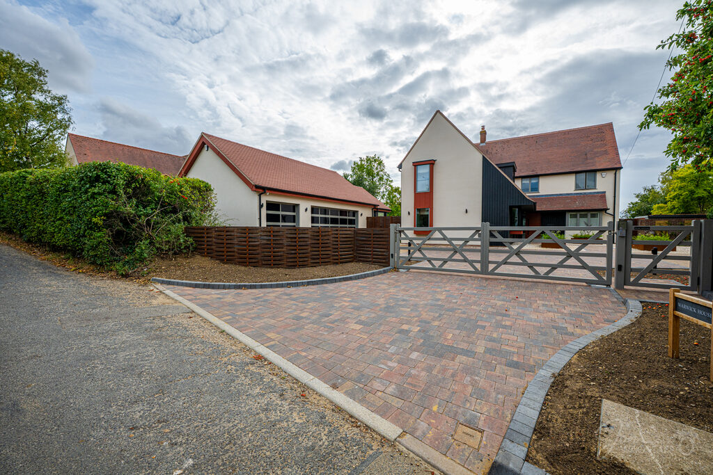 Warwick House gated entrance and driveway under a dramatic Essex sky, photographed by Jon Wagstaff