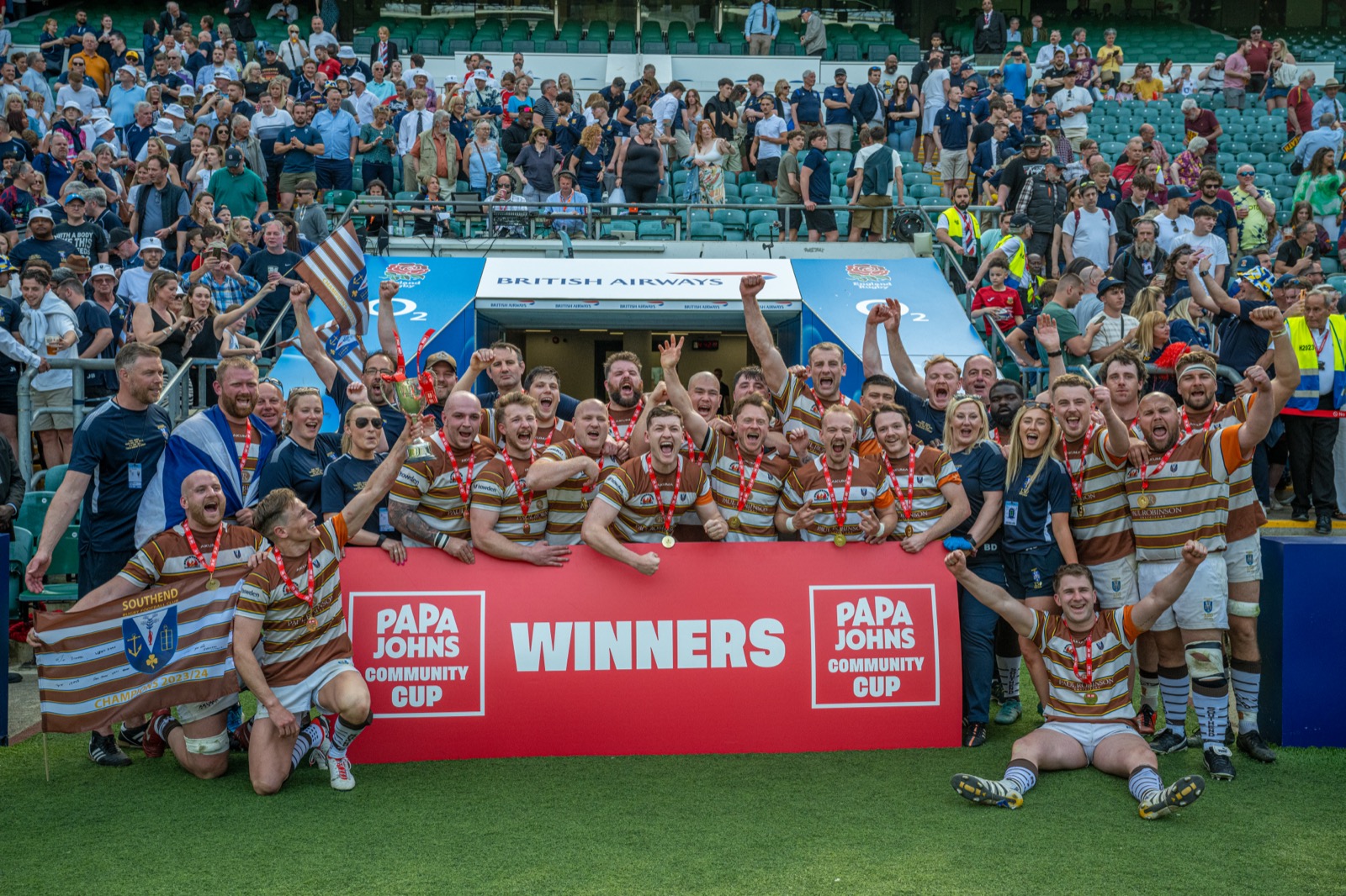 Rugby team celebrating with the Papa Johns Community Cup trophy after winning the final